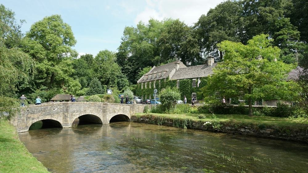 Stone bridge over the river in Bibury, one of the most photographed Cotswolds villages near London