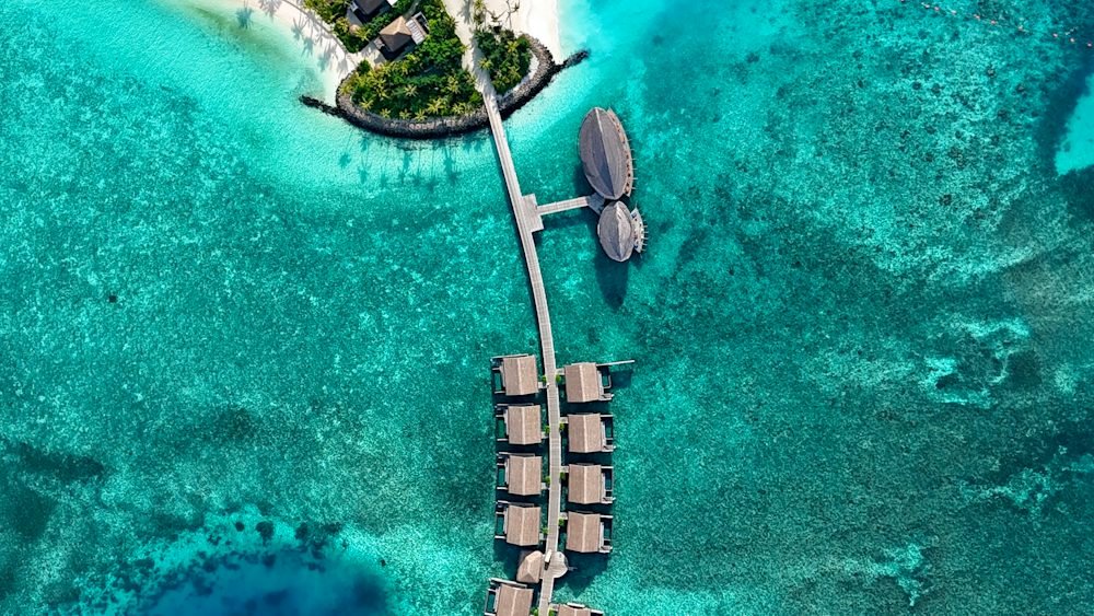 Aerial view of an overwater resort in the turquoise waters of the Maldives, a top luxury destination in May