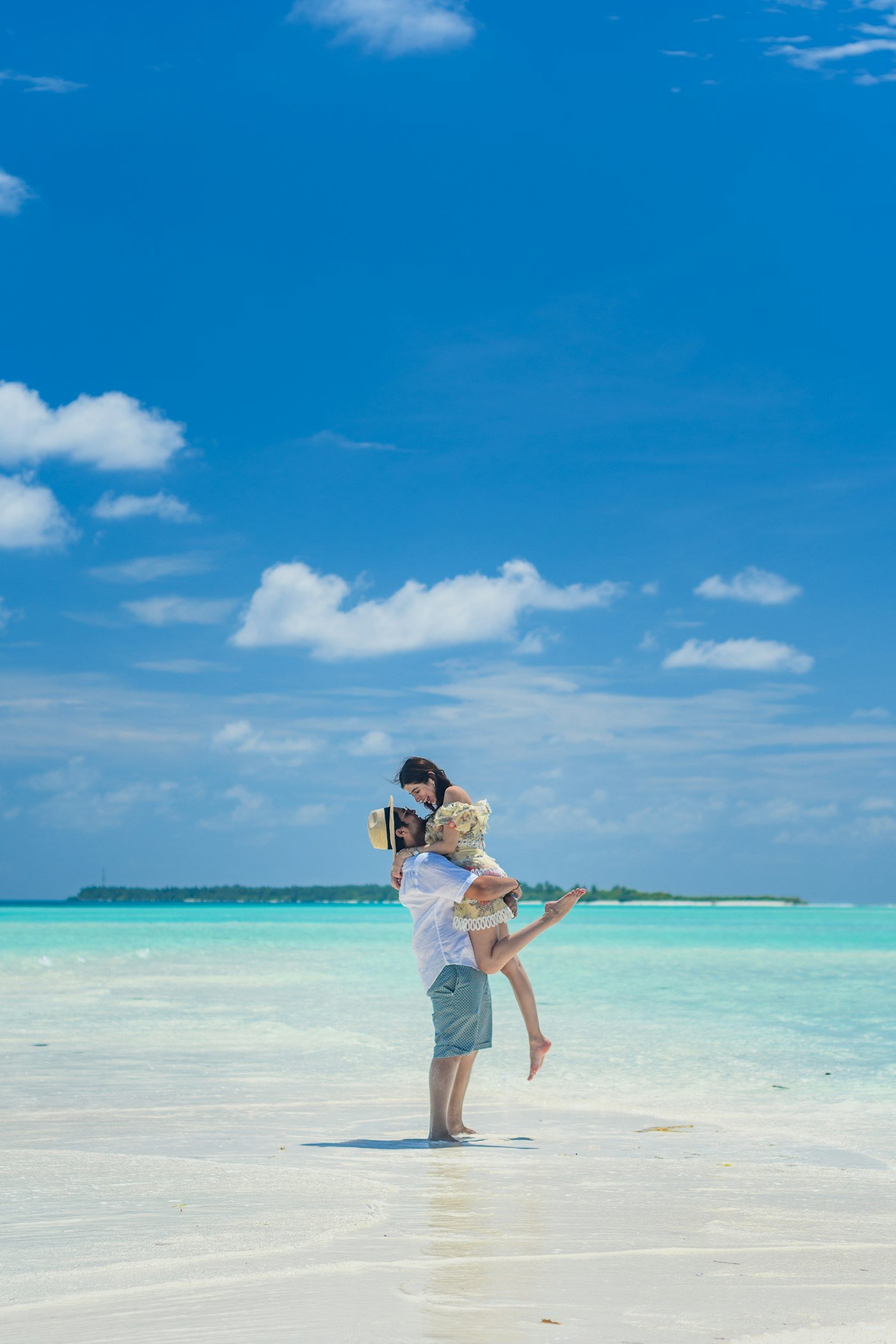 Woman standing on a white sand beach during a beach honeymoon destination