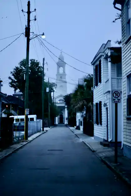 Charleston street leading to a historic church tower at dusk in summer